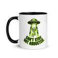 Mug with alien abduction design and text on a white background